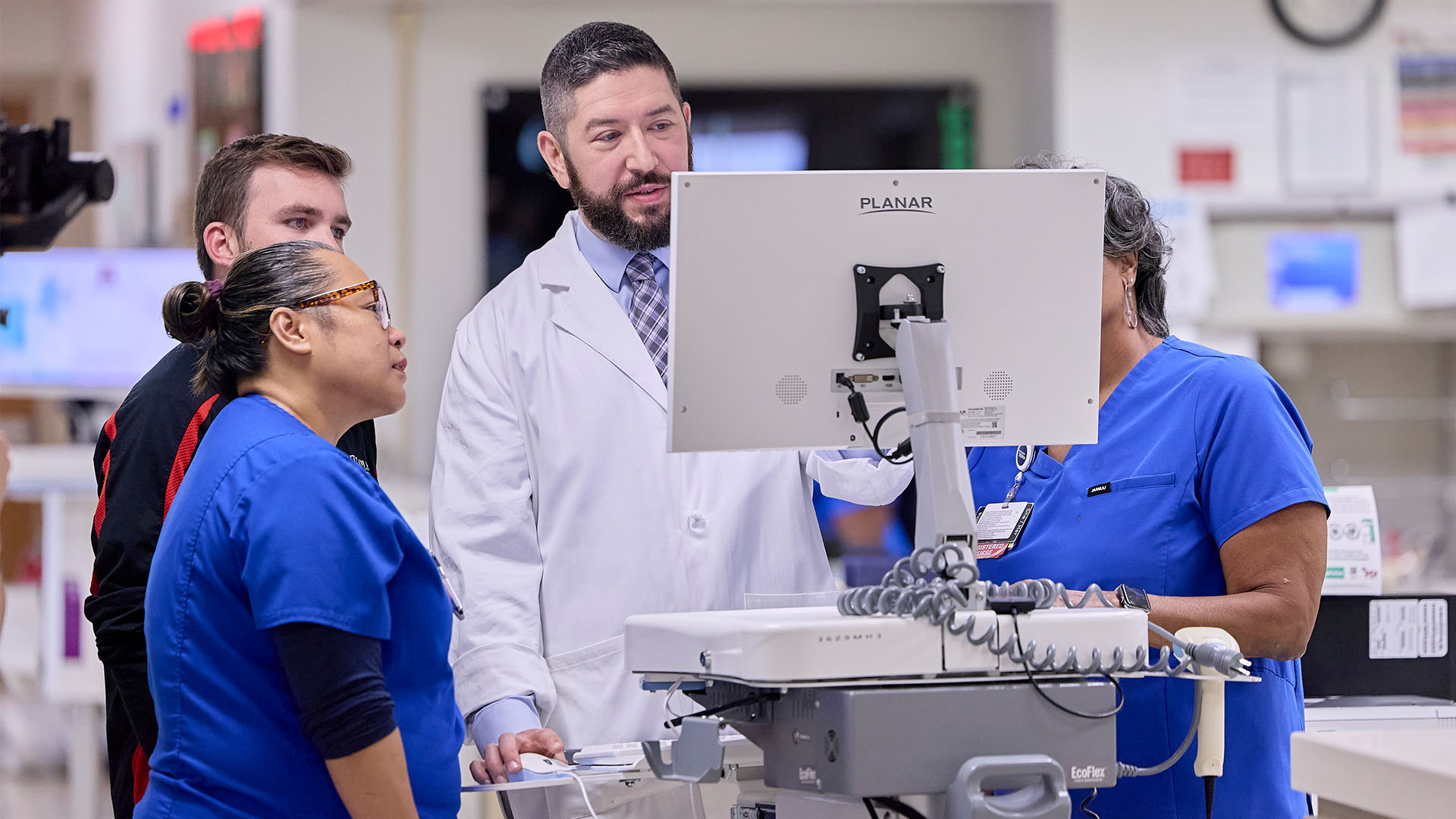 Clinical team members huddled around computer terminal