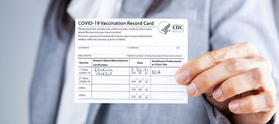 Woman holding Covid-19 vaccine card