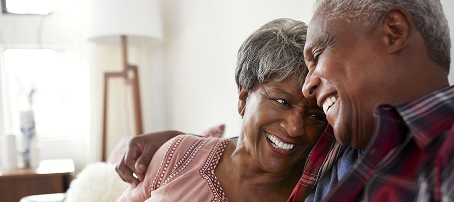 Senior couple hugging on the couch