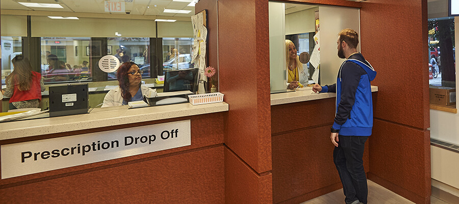 Patient picking up prescription at Temple Pharmacy window