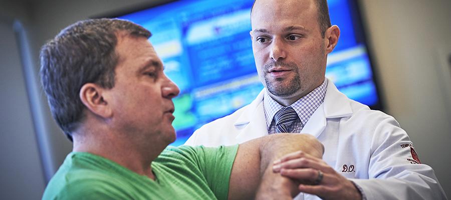 Orthopaedic physician testing arm movement