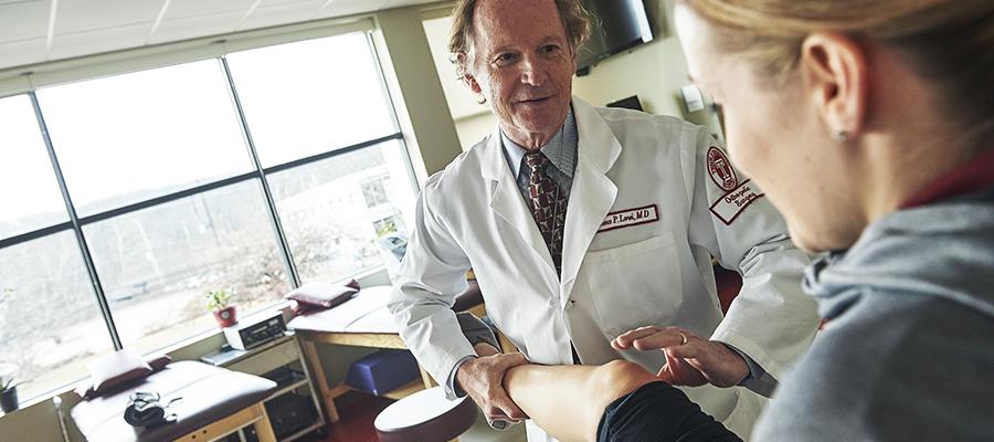 Orthopaedic physician testing knee movement 
