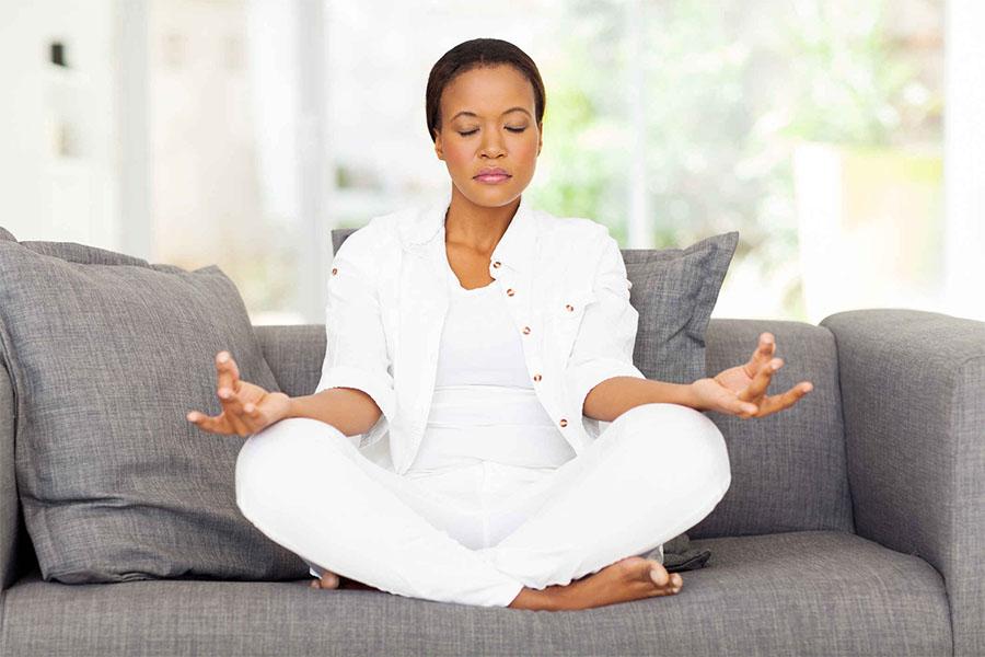 Woman sitting on the couch meditating