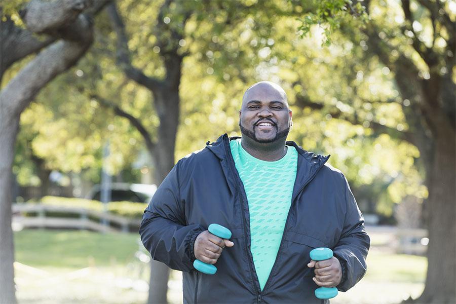 Man exercising outside with weights