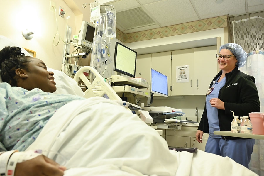 A Maternity team member checks in with, and provides support to, a pregnant patient.
