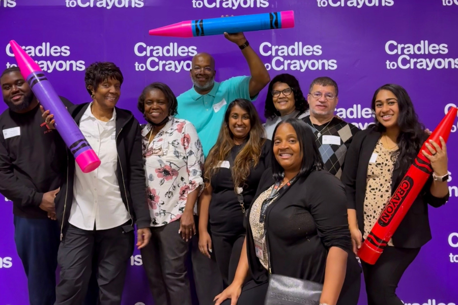 Volunteers from the Patient and Family Advisory Council and the Office of Patient Experience strike a playful pose at the Cradles to Crayons Giving Factory.