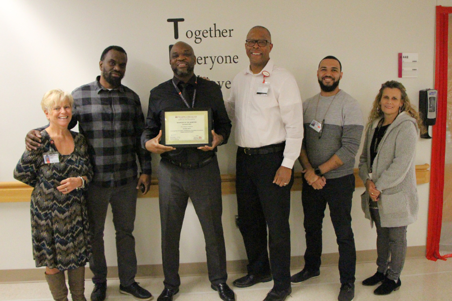 Smith (center left) and his colleagues celebrate his achievement.