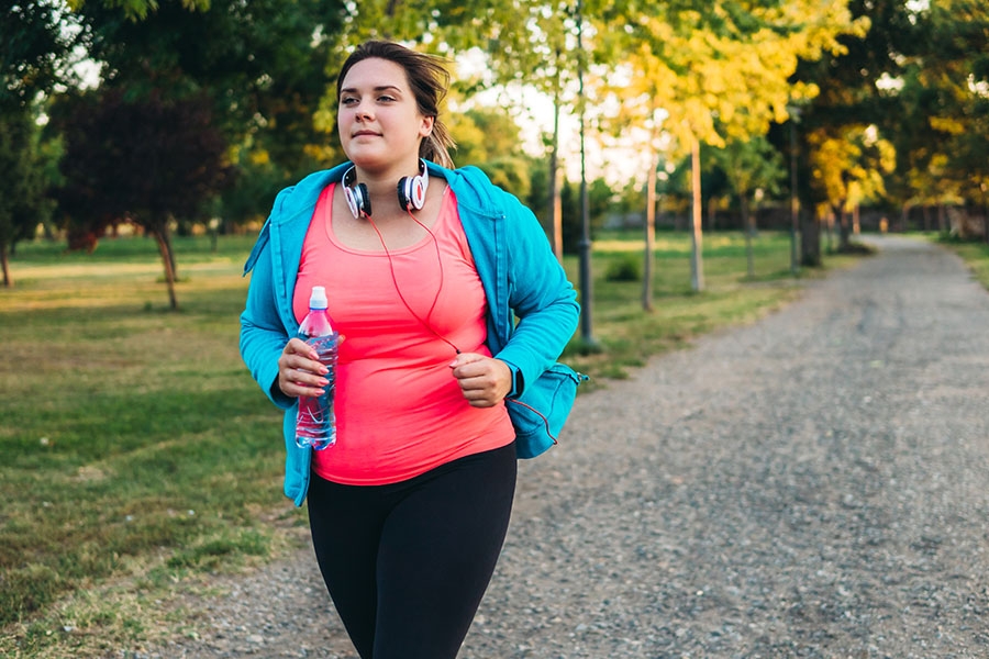 Woman running outside with water bottle