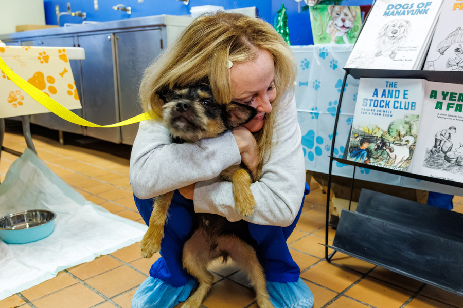Team Member at the Temple Tails Adoption Event Hugging a puppy