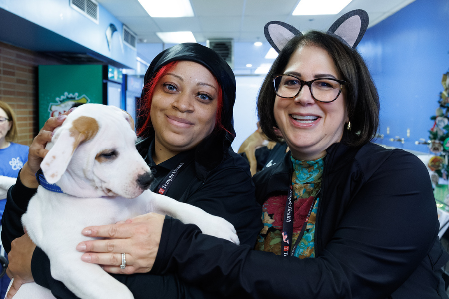 At the Temple Tails Adoption Event, team members share a moment with an adorable puppy