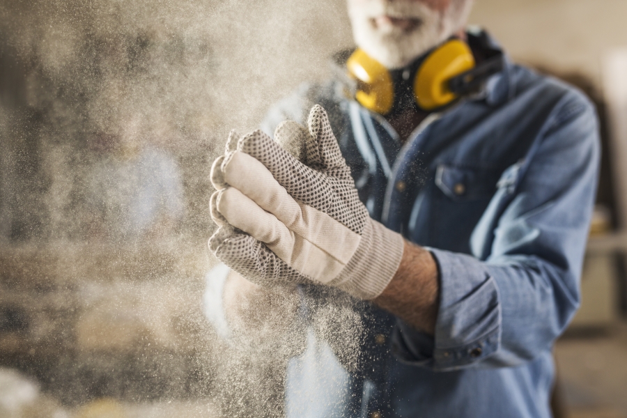 A worker wearing a dusty pair of gloves