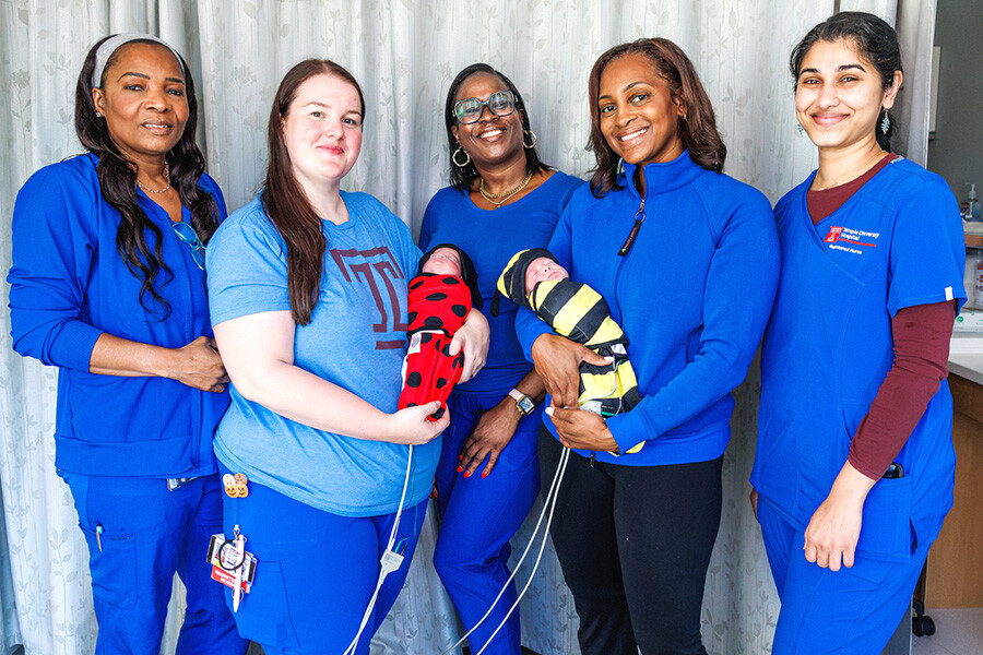 Newborn babies in costumes with NICU care team