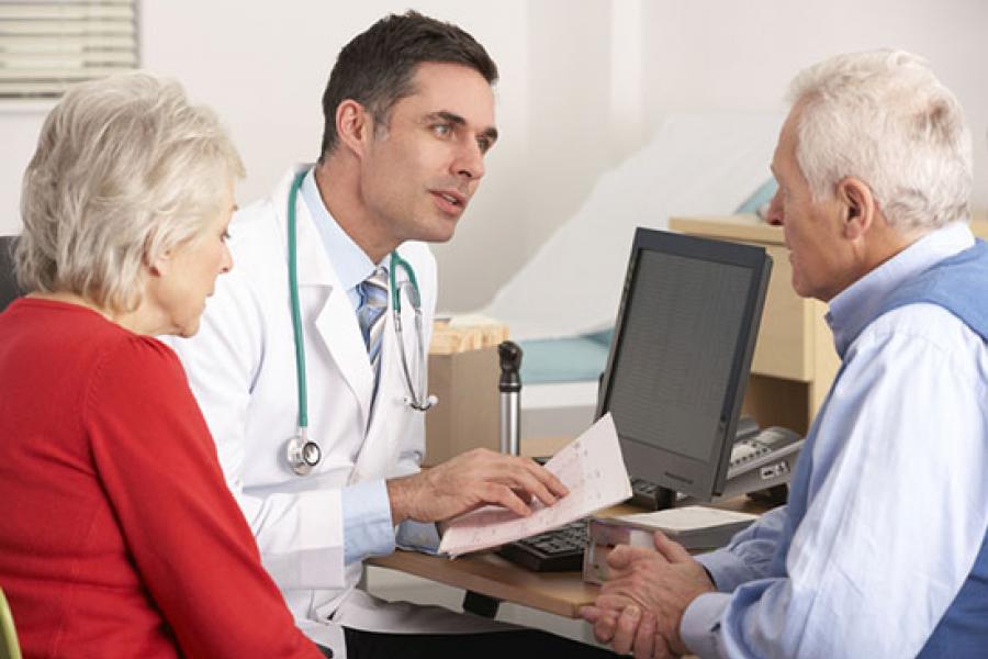 Temple physician explaining results to elder couple