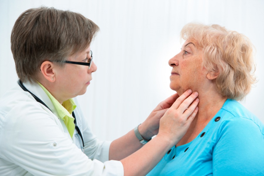 Doctor feeling patients throat