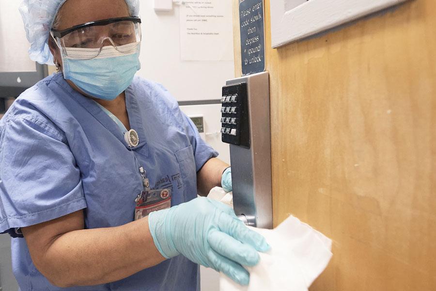 Temple staff cleaning and disinfecting door handle