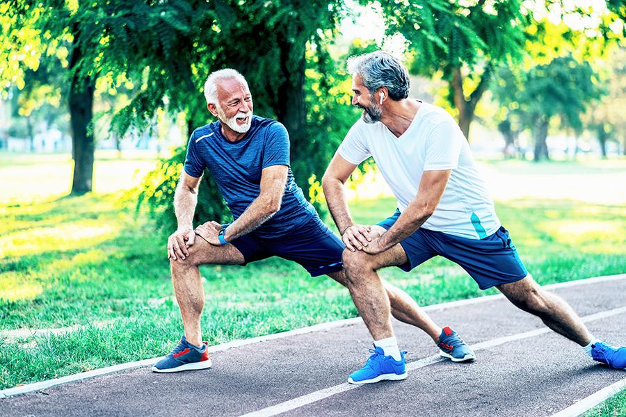 Two men stretching and talking before going for a run outside