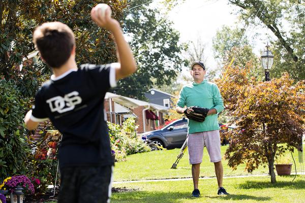 George P. playing baseball outside