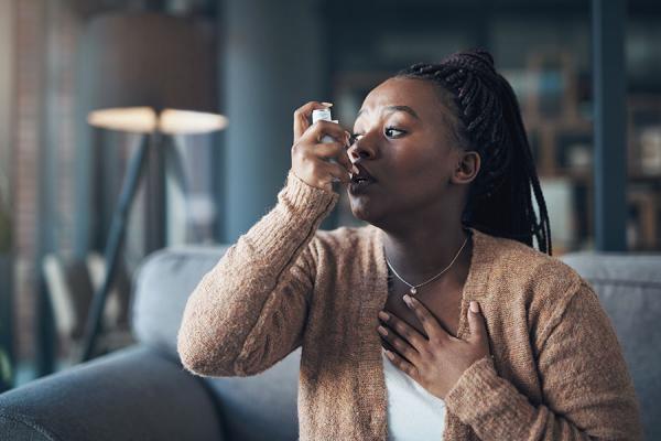 Woman using inhaler for her asthma