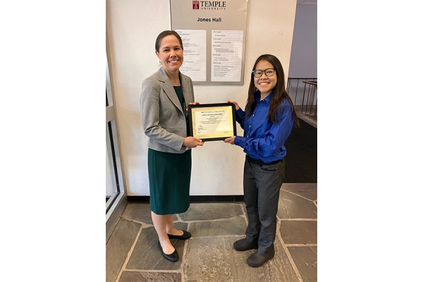 Dr. Choi (left) accepts her award from Nina O'Connor, MD, FAAHPM , Chair of the Department of Family and Community Medicine at the Lewis Katz School of Medicine at Temple University ; Chief of Service and Primary Care Service Line Director for Temple Faculty Physicians ; and Chief Medical Officer of the Temple Center for Population Health . 