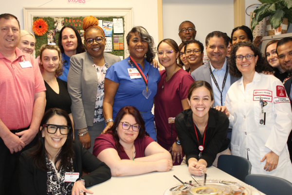 Stephanie Jones-Price, RN (center left, in blue) celebrates her award with her coworkers.