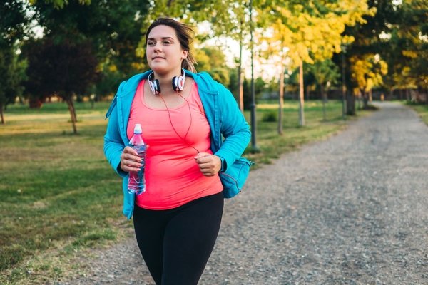 Woman running outside with water bottle