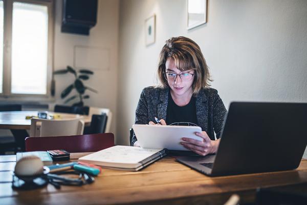 Young woman working from home at her laptop